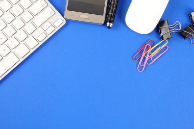 Mavi arka plan üzerinde ofis staioneries üst görünümü.