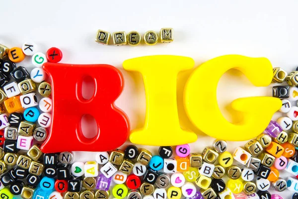 Word quotes of  Dream Big made from plastic alphabets over white background.