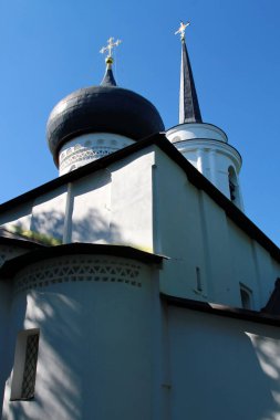 an ancient chapel against a blue sky with contrasting shadows