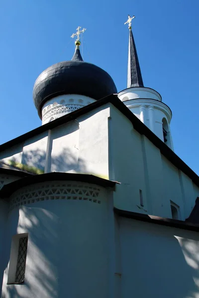 an ancient chapel against a blue sky with contrasting shadows