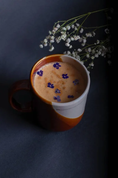 Sabah Kahvesi ve siyah arka planda güzel beyaz çiçekler ve çikolata. Sıcak bir kahvaltı. Düzleştirme biçimi.