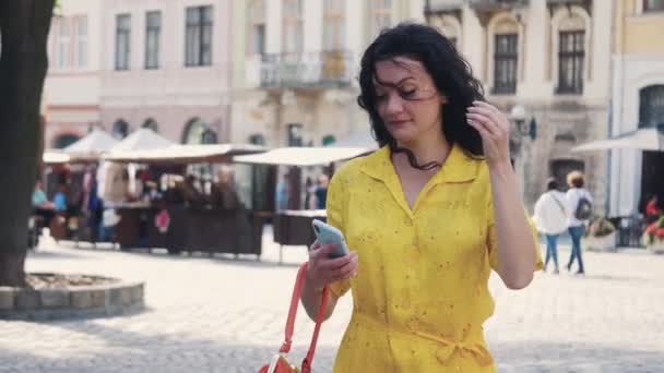 Vorderansicht einer aufgeregten Frau im gelben Kleid mit roter Handtasche Lizenzfreies Stock-Filmmaterial