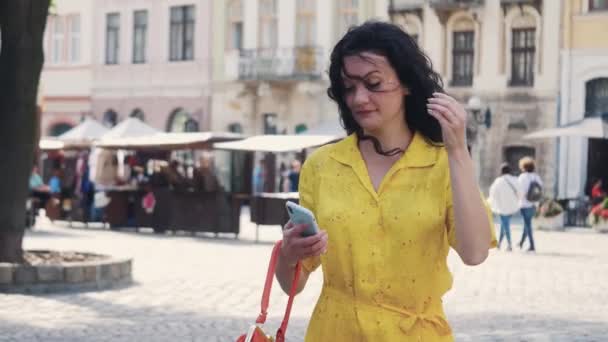 Vista frontal de uma mulher excitada vestindo vestido amarelo com bolsa vermelha c Filmagem De Stock Royalty-Free