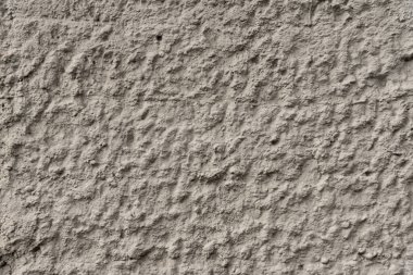 Binanın önündeki gri beton duvar. Beton yüzeyin engebeli dokusu..
