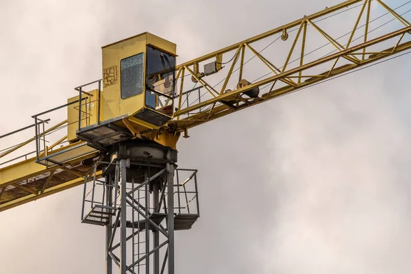 Work on a construction tower crane. Lifting loads to a height for building houses. High-rise metal structure for construction.