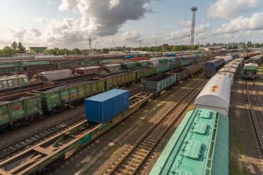 Demiryolu kavşağındaki tanklar ve yük vagonları. Çeşitli malların taşınması için uzun demiryolu trenleri. Demiryolu taşımacılığı lojistiği
