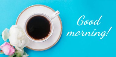 Beyaz kahve, beyaz ve pembe şakayıklar ve yazıtlar günaydın! Mavi bir arkaplanda romantik bir kahvaltı. Günaydın konsept. Seçici odaklanma, üst görüş.