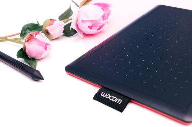 Kirov, Rusya - 27 Haziran 2020; Wacom grafik tableti ve pembe şakayıklı bir kalem birleşik beyaz ve pembe arkaplan. Yazı için alanı kopyala, sığ alan derinliğine sahip seçici odak