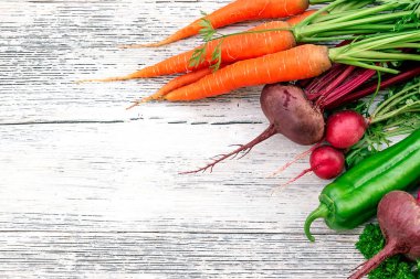 Pancar, turp, havuç, maydanoz ve yeşil dolma biber beyaz ahşap bir arka planda. Sağlıklı beslenme ve hasat kavramı. Kopya alanı, üst görünüm, düz yatış, seçici odaklanma.