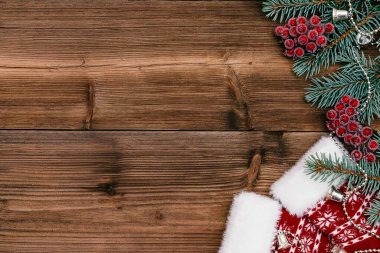 Noel çerçevesi koyu ahşap arka planda mavi köknar ağacı dalları, viburnum üzümleri ve Noel çoraplarından yapılmıştır. Noel arkaplanı. Yazı için yer, üst görünüm, düz yatış alanı kopyala