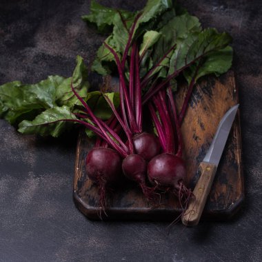 ahşap arka plan üzerinde bir kesme tahtası üzerinde çiğ kırmızı pancar