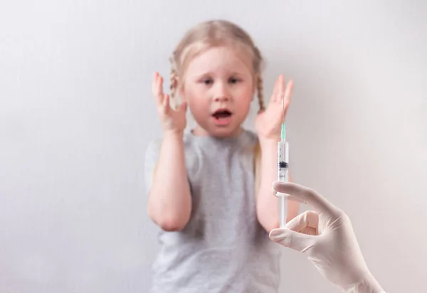 Маленька мила дівчинка, яка боїться ін'єкцій. Вакцинація дітей . — стокове фото