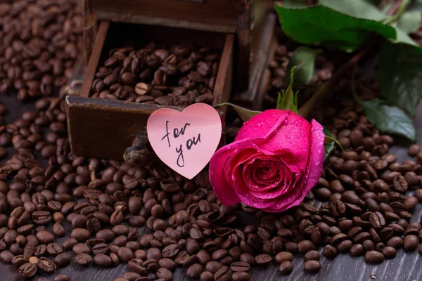Caneca de café preto e rosa em grãos de café torrados — Fotografia de Stock