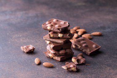 Koyu çikolata parçaları ve badem koyu arka plan üzerine yığını