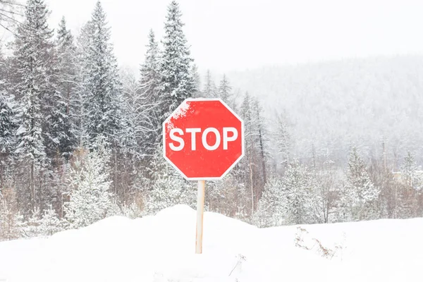 Stop road sign in snowy day in winter.