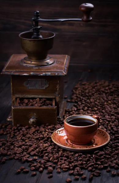 Черный кофе в чашке на фоне кофейных зерен — стоковое фото