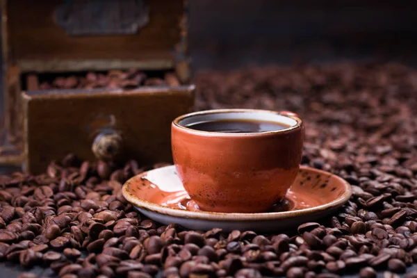 Черный кофе в чашке на фоне кофейных зерен — стоковое фото