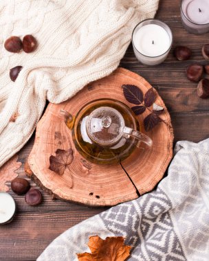 Tahta masada sonbahar yaprakları ve çaydanlık.