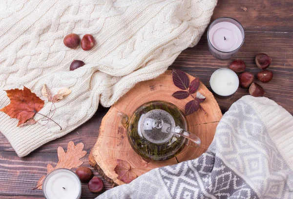 Folhas de outono e panela de chá na mesa de madeira — Fotografia de Stock