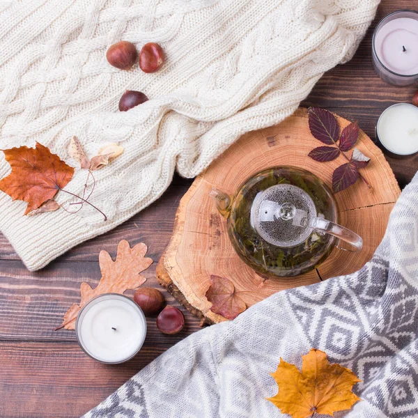 Осенние листья и чайник на деревянном столе — стоковое фото