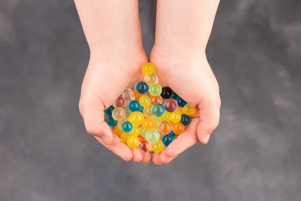 Water multiclooured gel balls. Child palms with hydrogel balls - orbeez. — Stock Photo, Image