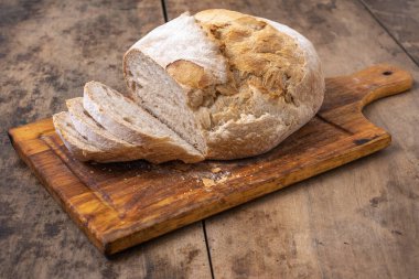 Bir masada dilimlenmiş organik buğday ekmeği ve un.