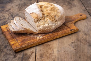 Bir masada dilimlenmiş organik buğday ekmeği ve un.