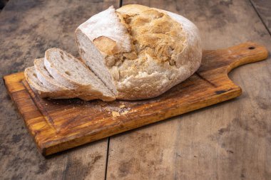 Bir masada dilimlenmiş organik buğday ekmeği ve un.