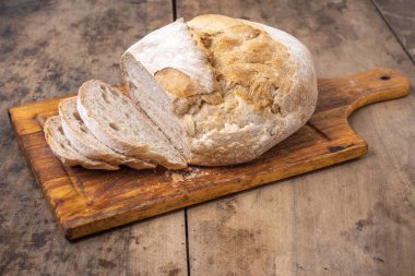 Bir masada dilimlenmiş organik buğday ekmeği ve un.