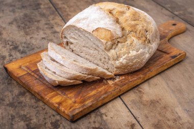 Bir masada dilimlenmiş organik buğday ekmeği ve un.