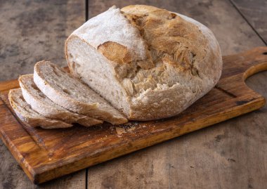 Bir masada dilimlenmiş organik buğday ekmeği ve un.