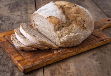 Bir masada dilimlenmiş organik buğday ekmeği ve un.