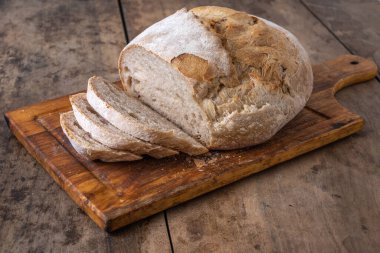 Bir masada dilimlenmiş organik buğday ekmeği ve un.