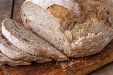 Bir masada dilimlenmiş organik buğday ekmeği ve un.