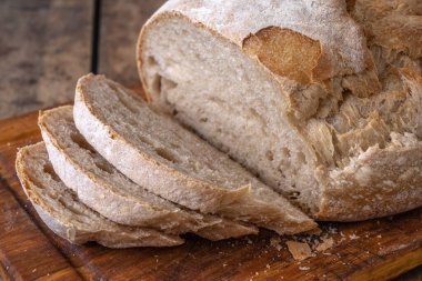 Bir masada dilimlenmiş organik buğday ekmeği ve un.