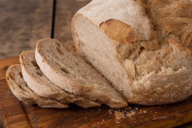 Bir masada dilimlenmiş organik buğday ekmeği ve un.