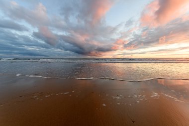Atlantik Okyanusu 'nda güneş batıyor. Fransa' da turuncu plaj ve gökyüzü var..