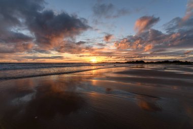 Atlantik Okyanusu 'nda güneş batıyor. Fransa' da turuncu plaj ve gökyüzü var..
