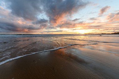 Atlantik Okyanusu 'nda güneş batıyor. Fransa' da turuncu plaj ve gökyüzü var..