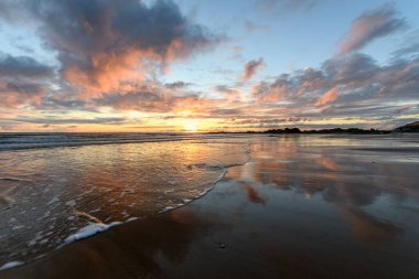 Atlantik Okyanusu 'nda güneş batıyor. Fransa' da turuncu plaj ve gökyüzü var..