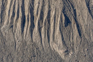 Karasal yüzey, kurak bölgede erozyon tarafından yontulmuş farklı çizgiler ve kabartmalar ortaya çıkarıyor. Bu doğal desenler jeolojik yerlerin hikayesini anlatır. Gornergletscher, Zermatt, valais, Alps, Swiss.