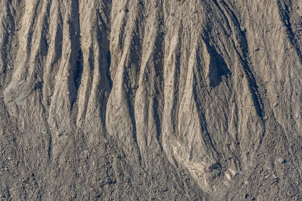 Karasal yüzey, kurak bölgede erozyon tarafından yontulmuş farklı çizgiler ve kabartmalar ortaya çıkarıyor. Bu doğal desenler jeolojik yerlerin hikayesini anlatır. Gornergletscher, Zermatt, valais, Alps, Swiss.