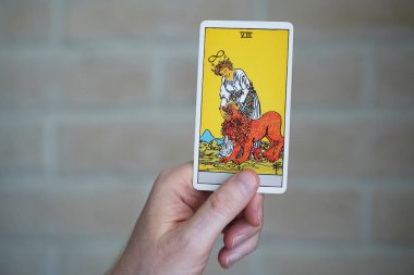 Bulanık arkaplan tarot kartları, ön plandaki güç kartı.