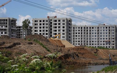 Vinçleri ve mavi gökyüzü arka planlı binaları olan bir sürü kule inşaat alanını bulanıklaştırmış. Yüksek kalite fotoğraf