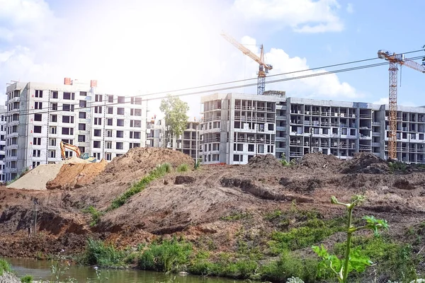 Vinçleri ve mavi gökyüzü arka planlı binaları olan bir sürü kule inşaat alanını bulanıklaştırmış. Yüksek kalite fotoğraf