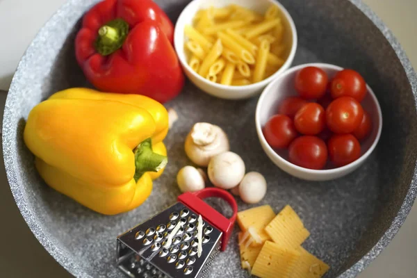 Composición borrosa de los alimentos de pasta, diferentes ingredientes en una sartén —  Fotos de Stock