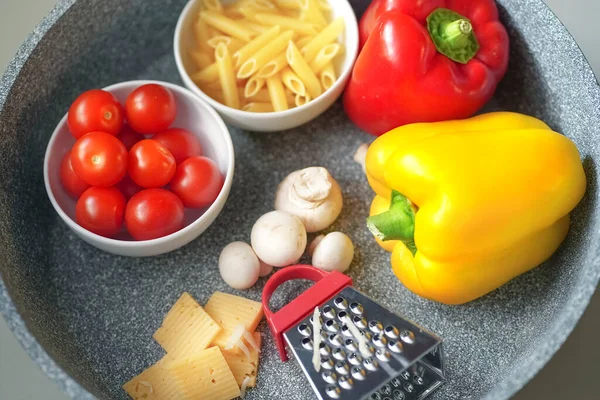 Verschwommene Zusammensetzung von Nudeln, verschiedene Zutaten in einer Pfanne — Stockfoto