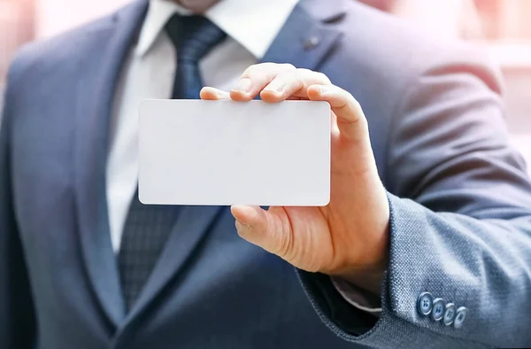 Blurred businessmans hand showing business card