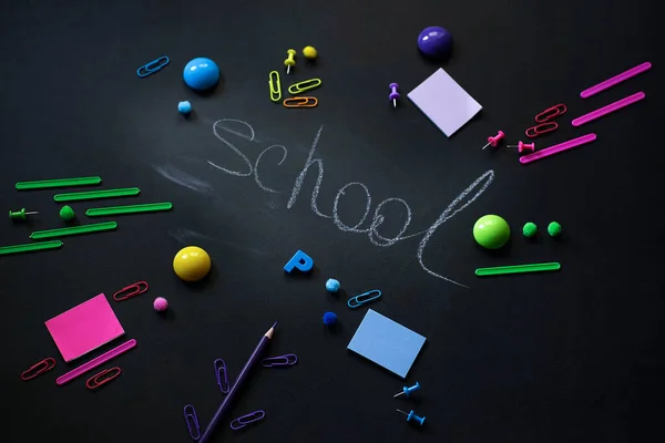 Back Schoolのコンセプトアラームクロックの背景のぼやけた背景黒の背景にあるBlackboard Pencilのステーショナリー トップ表示フラットレイ 高品質の写真 — ストック写真