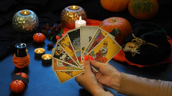 Tarot reader with tarot cards. Halloween concept, black magic or fortune telling rite with occult and esoteric symbols. High quality photo